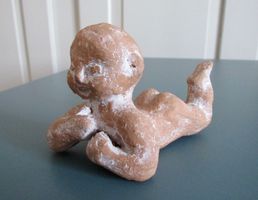 kleine Plastik / Tonfigur: liegendes Baby