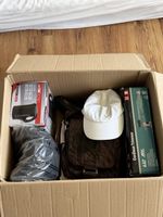 Karton mit diversen Artikeln: Wasserkocher, Trimmer, Tasche