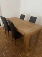 Esstisch in warmer Holzoptik mit 4 schwarzen Polsterstühlen