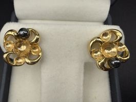 Elegante goldfarbene Vintage-Ohrringe mit dunkler Perle.