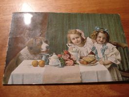 Kitschkarte "Mädchen mit Hund, gedeckter Tisch " 1913, kolor
