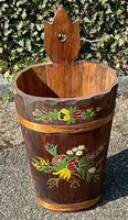 Antiker Holzeimer mit traditionellem Blumenmotiv.