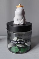 Schwarzes Vorratsglas mit Betonfrosch