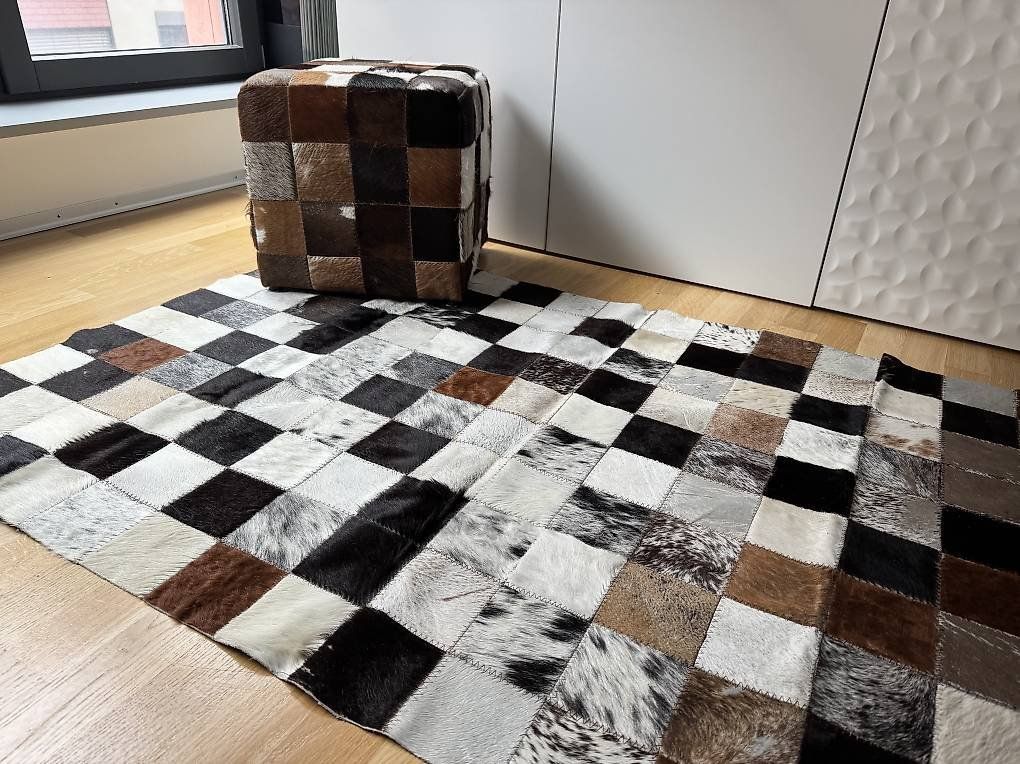 Tappeti: Echtes Kuhfell Patchwork Set: Teppich & Sitzhocker – Usato da Herisau venduto da Dinge-in-Bewegung