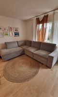 Graues Ecksofa mit Armlehne und Schlaffunktion