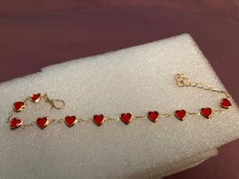 schönes, zartes, goldfarbenes Armband mit roten Glas-Herzen