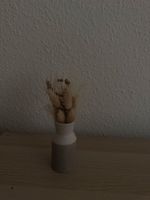 Kleine Keramikvase mit getrockneten Blumen