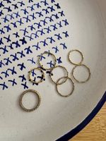 7 gold colored stacking rings in various sizes
