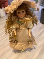 Poupée en porcelaine sur support en acier