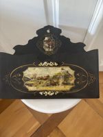 Porte-revues vintage en bois noir avec motifs champêtres.