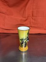 Gelbe Vase mit Kieferast und herausstehende Biene