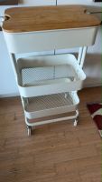 White rolling storage cart with a bamboo top.