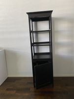 Schwarzes Regal mit einer Türe und offenen Fächern