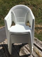 7 weisse Stapelstühle mit 8 Kissen