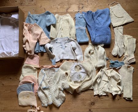 Schachtel mit sehr alten Baby- und Kinderkleidern