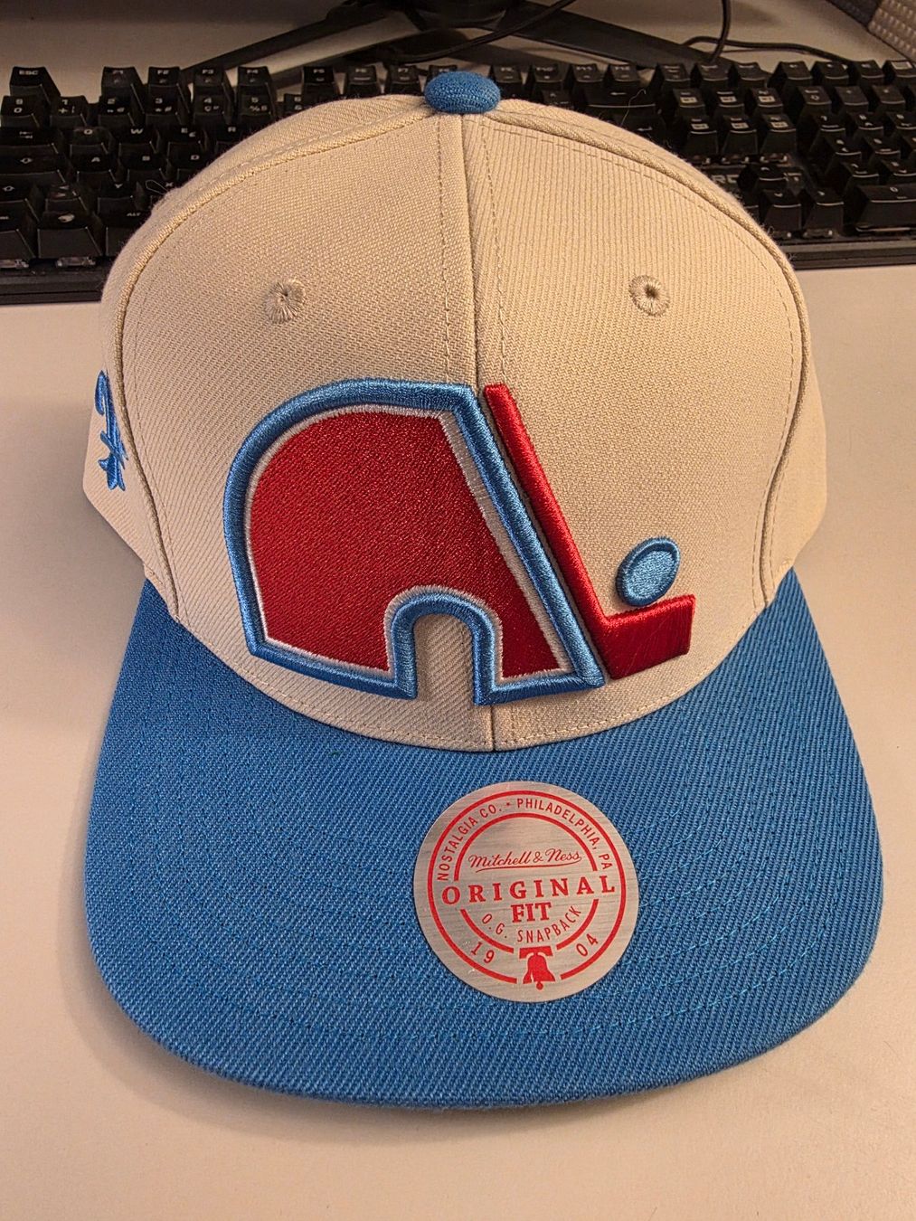 Mitchell & Ness Copricapi, berretti & cappellini: Cap Mitchell & Ness Original Fit Snapback Quebec Nordiques – Nuovo e nell'imballaggio originale da Mörigen venduto da Gadgeteer