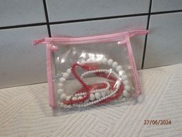 Plastiktäschchen mit gebrauchten Halsketten, Modeschmuck