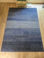 Tapis dans des nuances de bleu assez épais en laine