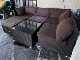 Divano da giardino in rattan con tavolino e cuscini