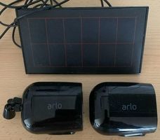 2 Arlo-Kameras mit einem Solarpanel.