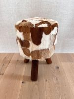 Gemütlicher Holzhocker mit Ziegenfell