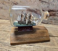 Schiffsmodell in Flasche auf Holzständer Dekoration