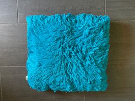 Türkisfarbenes, flauschiges Kissen