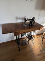 Alte Nähmaschine mit antikem Tisch