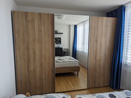 Schwebetürenschrank aus Holz mit Spiegel