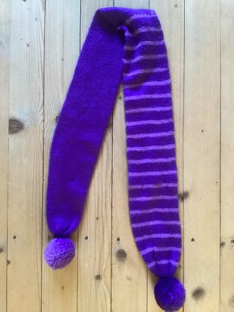 Warmer gestrickter, violetter Schal mit Bommeln und Streifen