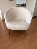 Weisser Sessel mit goldenen Beinen