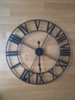 Schwarze Wanduhr mit 60 cm Durchmesser.