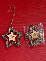 Weihnachtsstern mit Glöckchen und Holzstern inmitten