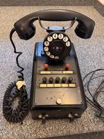Antikes Telefon schwarz mit Wählscheibe und Knöpfen