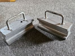 Zwei Metallgewichte mit Griffen. Beschwerungssteine
