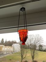 Rote Glasampel in Metallkorb