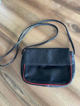 Ledertasche schwarz mit roter Kante.