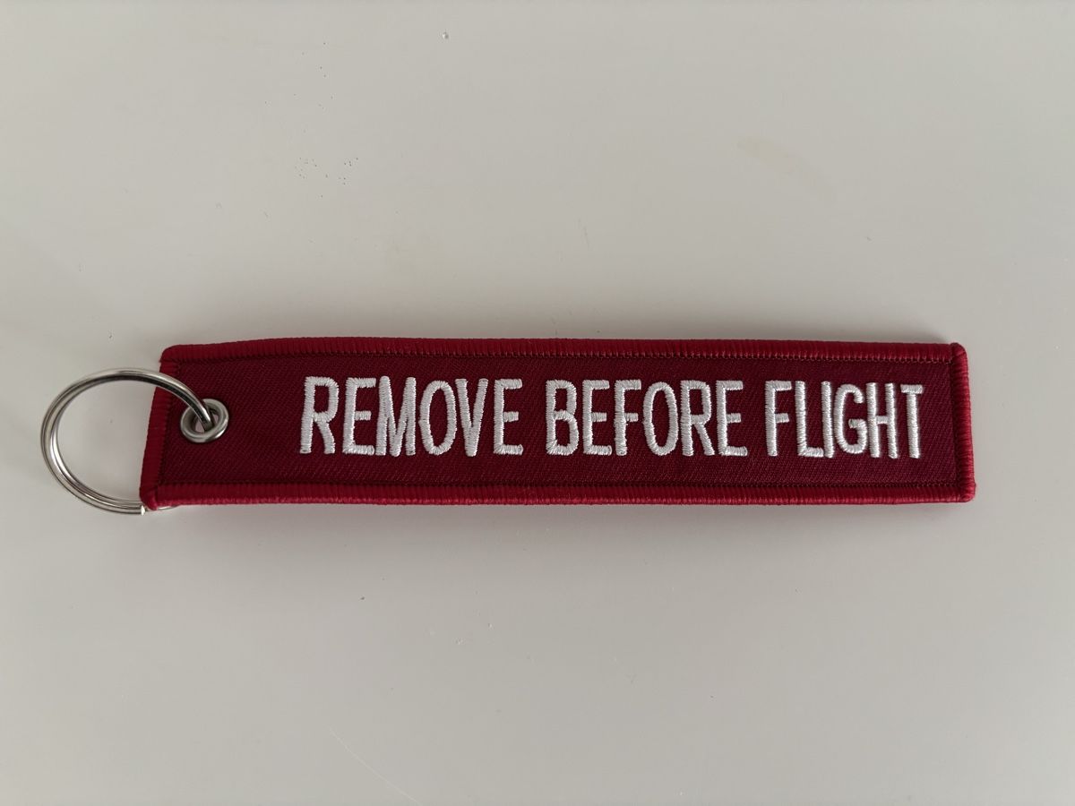 Portachiavi: SWISS "REMOVE BEFORE FLIGHT" Schlüsselanhänger, Rot – Nuovo e nell'imballaggio originale da Bülach venduto da Karuna