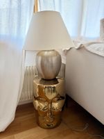 Elegante Tischleuchte mit goldenem Sockel Gesicht