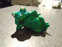 Frosch grün, auf einem Arm aufgestützt