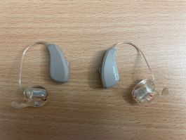 Hörgerät von Amplifon mit Ladestation und Aufbewahrungsbox