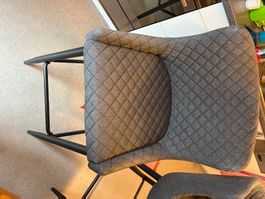 Grey quilted dining chair with black metal legs. Cozy!