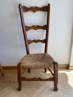 Rustikaler Holzstuhl mit hoher Lehne und niedriger Sitzhöhe