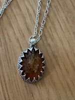 Pendentif ambre avec chaînette argentée ovale décoré