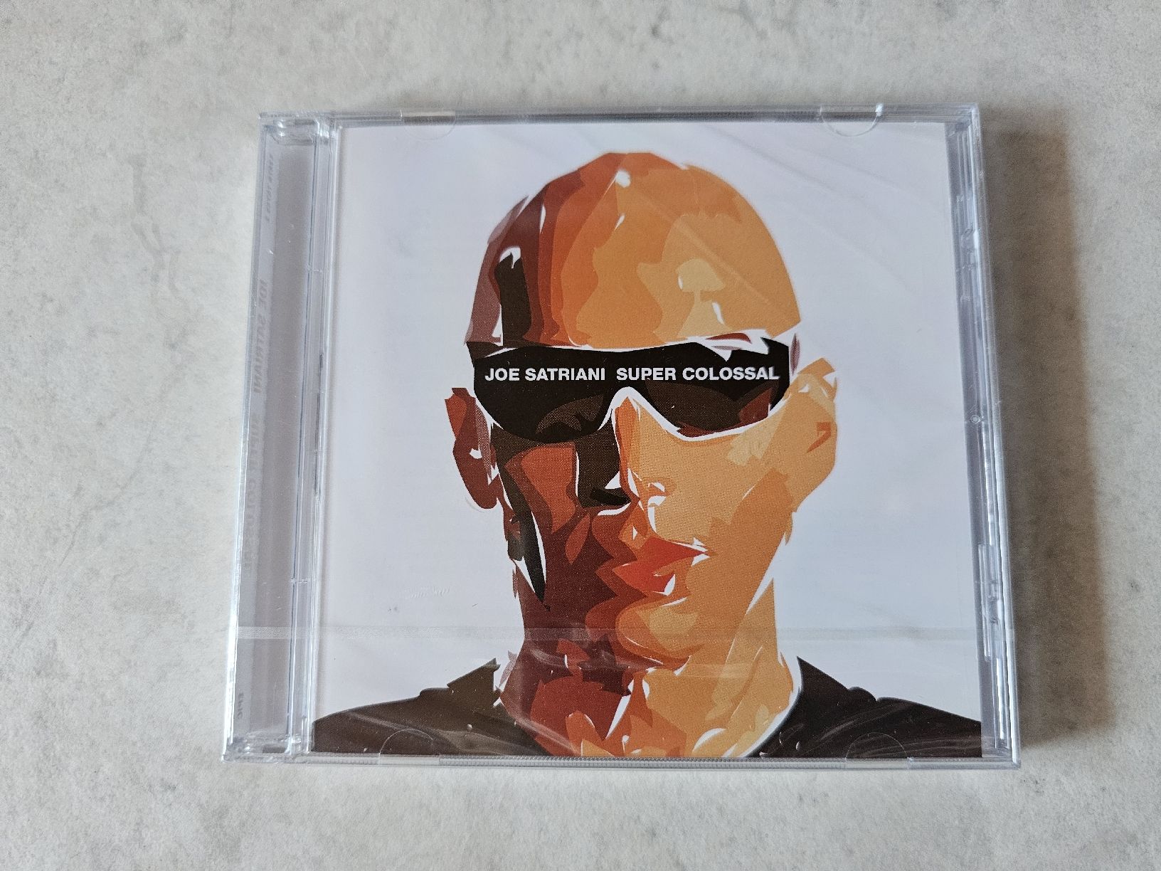 CD: Joe Satriani  -  Super Colossal  /  Fabrikneu – Nuovo e nell'imballaggio originale da Schneisingen venduto da backstore24