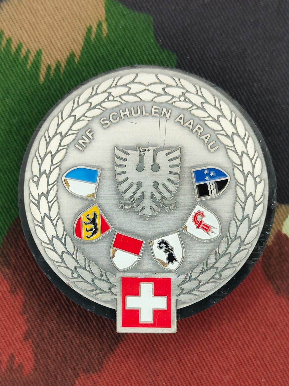 Schweizer Armee Plaketten & Abzeichen: Béretemblem Infanterieschulen Aarau, Variante 1 – Gebraucht aus Bauma von SwissMilitaria