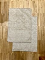 A pair of beige velvet pillow cases