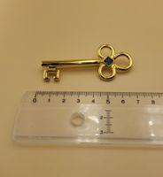 Goldene Brosche Schlüssel mit blauem Stein