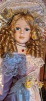 Süsse Porzellanpuppe mit blonden Locken