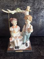 Figurine enfants sur balançoire .